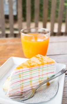 Banana caramel crepe cake and fresh orange juice, stock photo