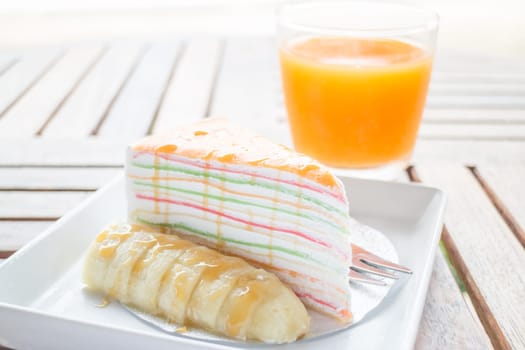 Energy charge dessert with banana caramel crepe cake and fresh orange juice, stock photo