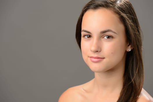 Beautiful teenage girl skin care cosmetics on gray background