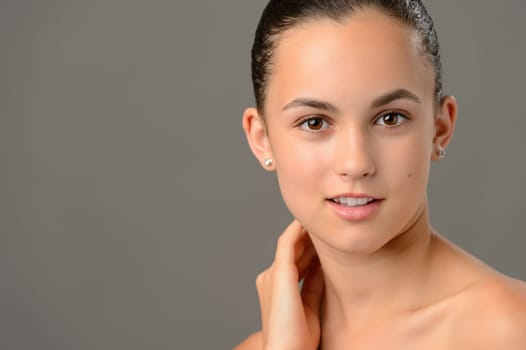 Teenage girl face cosmetics skin care close-up on gray background
