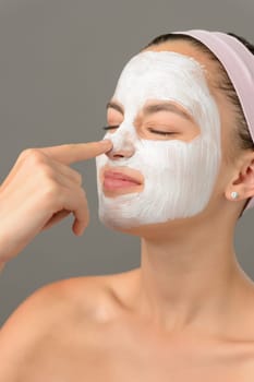 Teenage beauty girl touch nose white facial mask closed eyes