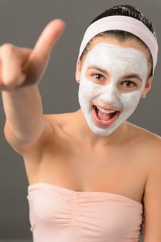 Teenage girl facial mask beauty thumb-up shouting on gray background