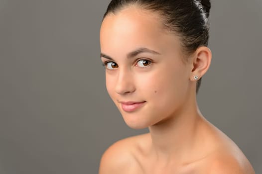 Beauty face teenage girl cosmetics skin care on gray looking camera