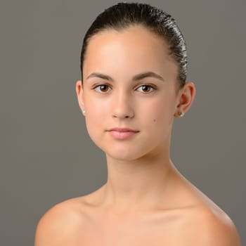 Teenage girl bare shoulders skin care beauty portrait on gray background