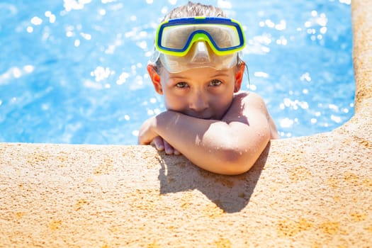 Happy girl with goggles relaxing in swimming pool