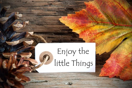 A Fall Label with the Life Quote Enjoy the little Things, on Wood