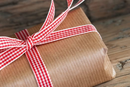 Closeup of a Rustic Present, Gift Wrapped with Red White Ribbon