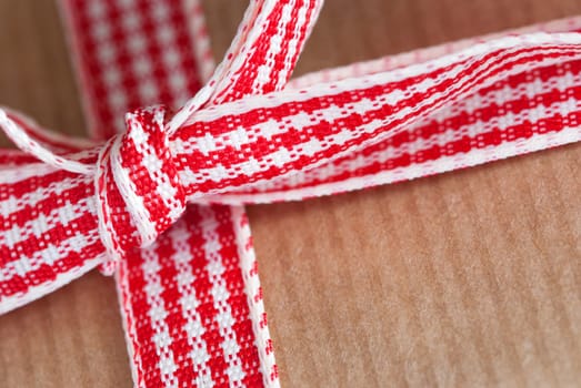 Present Ribbon Closeup in Red White on a Brown Background