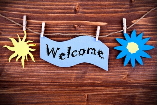 Purple Label with the Word Welcome, Hanging on a Line with a Sun and a Flower