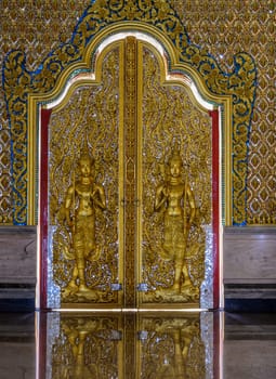 Traditional Thai sculpture style on temple door in Thailand