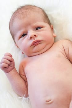 Little baby toddler newborn naked on a white fur as Detal