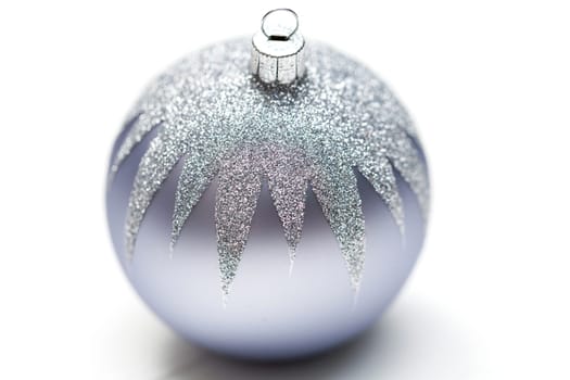 Glittering silver Christmas bauble on white background Macro detail
