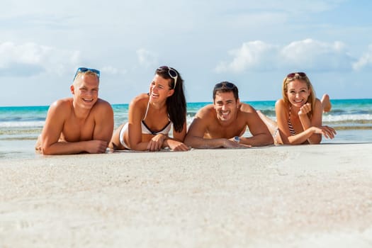 group of laughing young people on the beach in summer holiday leisure lifestyle