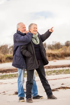 older adult happy couple walks on the beach in autumn lifestyle happiness