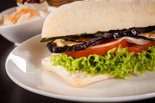 Vegetarian vegan hamburger with aubergine tomato and salad in a ciabatta bun