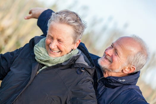 older seniors couple happy laughing in holiday leisure natural ostsee