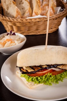Vegetarian vegan hamburger with aubergine tomato and salad in a ciabatta bun