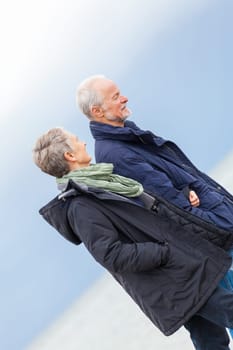 older adult happy couple walks on the beach in autumn lifestyle happiness