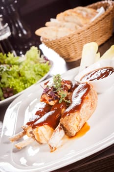 Grilled pork ribs Spareribs with barbecue sauce marinade and herb salad on a plate