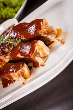 Grilled pork ribs Spareribs with barbecue sauce marinade and herb salad on a plate