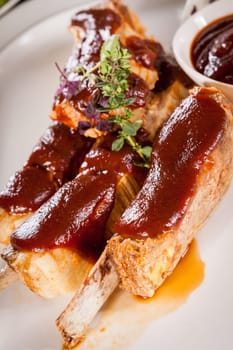 Grilled pork ribs Spareribs with barbecue sauce marinade and herb salad on a plate