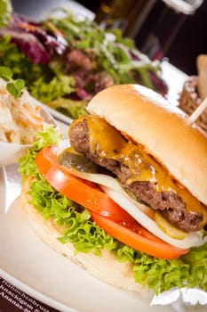 Delicious hamburger cheeseburger with bacon egg and salad on a plate