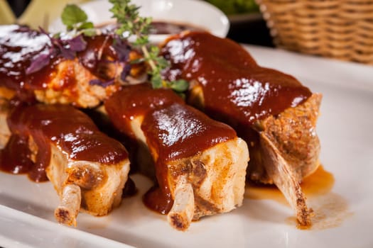 Grilled pork ribs Spareribs with barbecue sauce marinade and herb salad on a plate