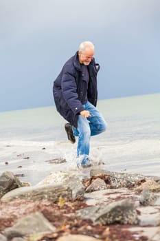 older adult happy couple walks on the beach in autumn lifestyle happiness
