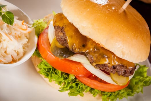 Delicious hamburger cheeseburger with bacon egg and salad on a plate