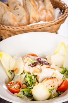 Fresh delicious caesarsalat with grilled chicken bust parmesan splinters and croutons
