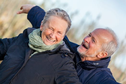 older seniors couple happy laughing in holiday leisure natural ostsee