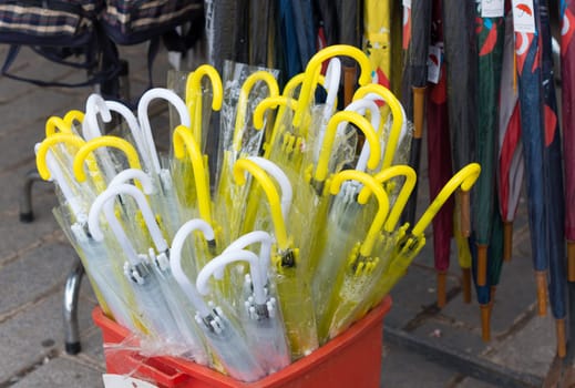 yellow and white umbrellas for sale at a stand