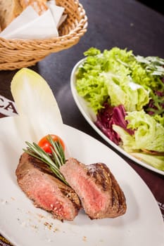 Medium fried beef steak fillet with pepper and rosemary sliced on a plate