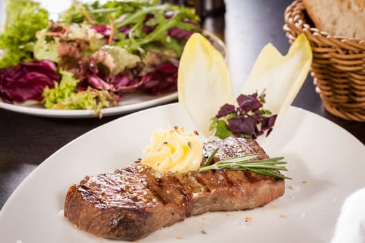 Succulent grilled beef fillet steak with homemade herb butter on a plate