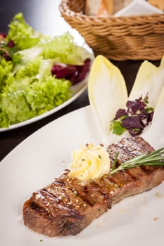Succulent grilled beef fillet steak with homemade herb butter on a plate