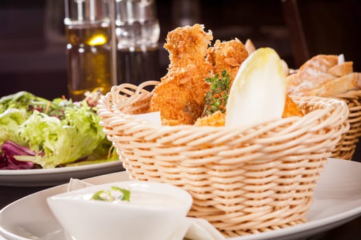 Crispy fried chicken wings with a dip on a plate