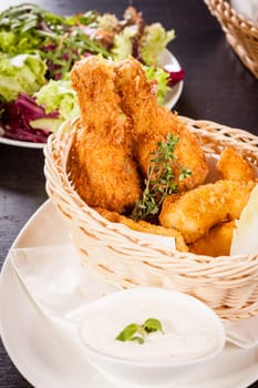 Crispy fried chicken wings with a dip on a plate