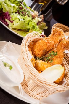 Crispy fried chicken wings with a dip on a plate
