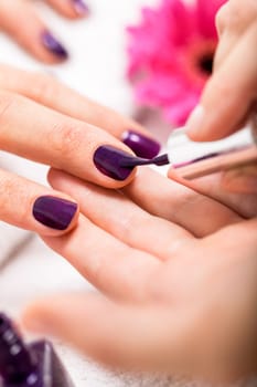 woman gets her nails in purple painted nail salon salon cosmetic care