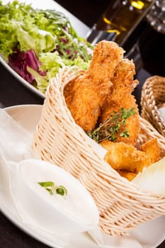 Crispy fried chicken wings with a dip on a plate
