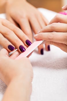 Professional nail designer at a manicure with female hands in a nail salon