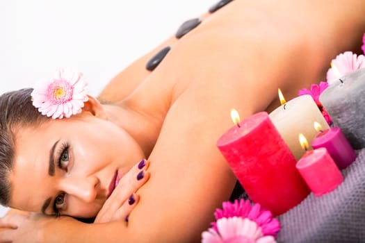 young attractive woman relaxed at a hot stone massage wellness spa salon health