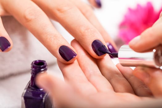 woman gets her nails in purple painted nail salon salon cosmetic care