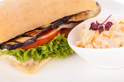 Vegetarian vegan hamburger with aubergine tomato and salad in a ciabatta bun isolated on a white background