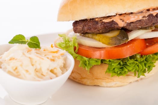 Delicious hamburger cheeseburger with bacon egg and salad on a plate isolated on a white background