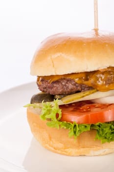 Delicious hamburger cheeseburger with bacon egg and salad on a plate isolated on a white background