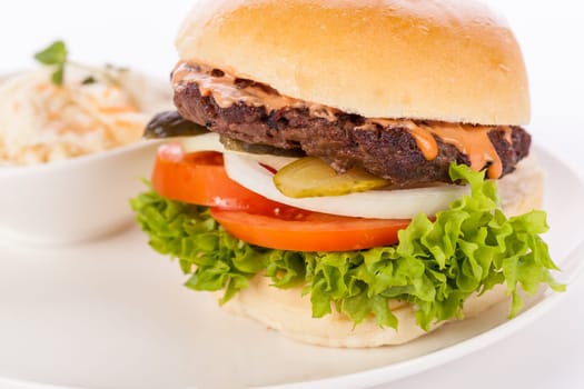 Delicious hamburger cheeseburger with bacon egg and salad on a plate isolated on a white background