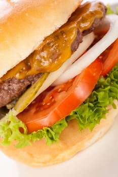 Delicious hamburger cheeseburger with bacon egg and salad on a plate isolated on a white background