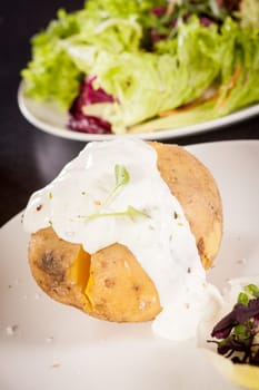 fresh foilpotato from the oven with herb quark sour cream and fresh herbs