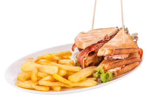 Club sandwich on toasted white bread with bacon and fries fried fries on a plate isolated against a white background